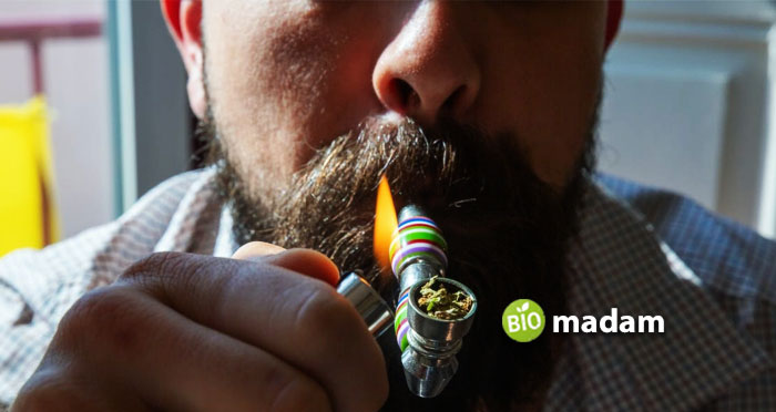 A-man-smoking-cannabis-using-a-pipe