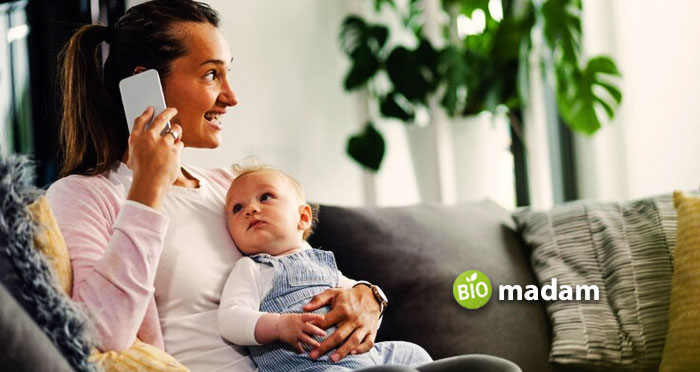 Mother-and-Baby-on-Sofa-and-woman-use-Smartphone